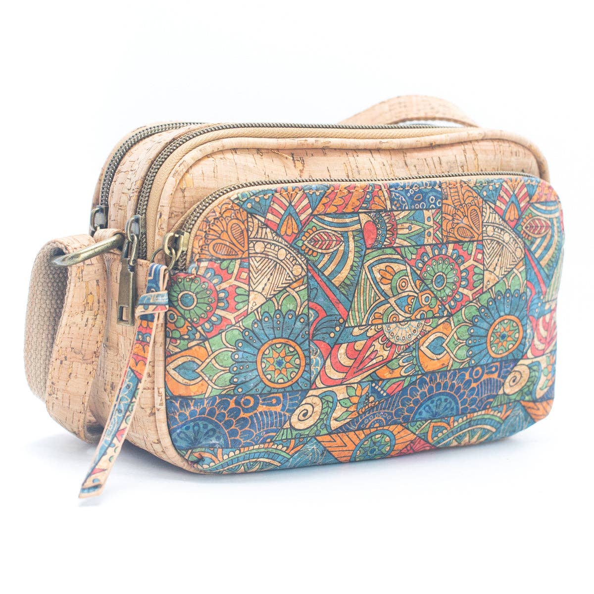 A multicolored printed crossbody bag with cork material and a floral and geometric pattern, featuring an adjustable strap and multiple zippered compartments.